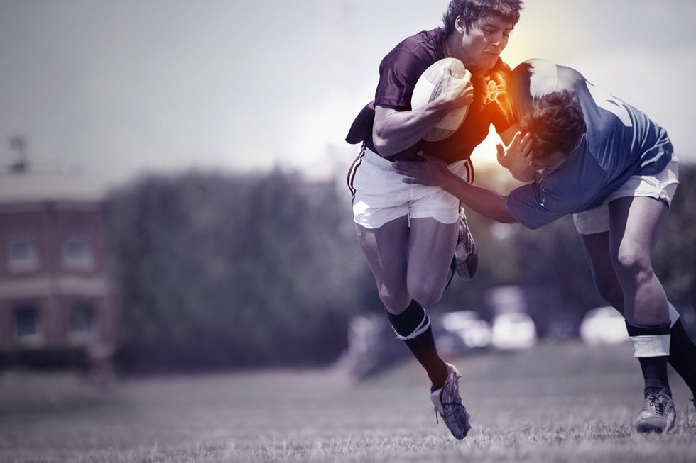 A rugby player being tackled during a game and sustaining an injury
